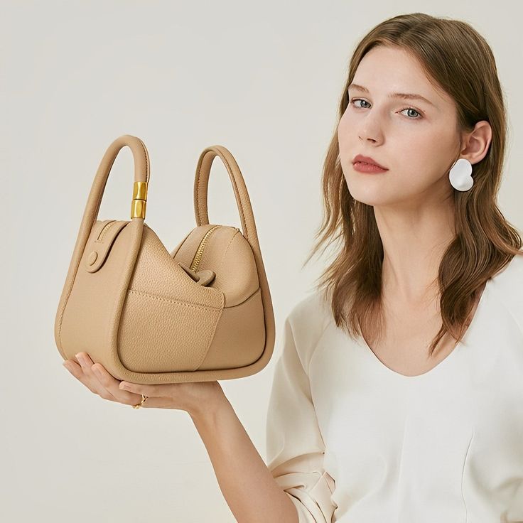 Looking for a versatile shoulder bag that oozes style and quality? Look no further than the Kelly Shoulder Bag! Lightweight and versatile, this bag is perfect for any occasion while easily fitting all your essentials. Whether dressed up or down, you'll confidently go anywhere with this must-have statement piece on your shoulder. Now available in beige and khaki. On-the-go Crossbody Baguette Bag With Top Handle, Versatile Satchel Shoulder Bag With Top Carry Handle, Versatile Handheld Bag With Detachable Strap, Versatile Handheld Shoulder Bag, Versatile Beige Crossbody Box Bag, Trendy Top Handle Shoulder Bag For On-the-go, Versatile Canvas Shoulder Bag, Versatile Evening Shoulder Bag, Versatile Baguette Bag With Top Handle And Adjustable Strap