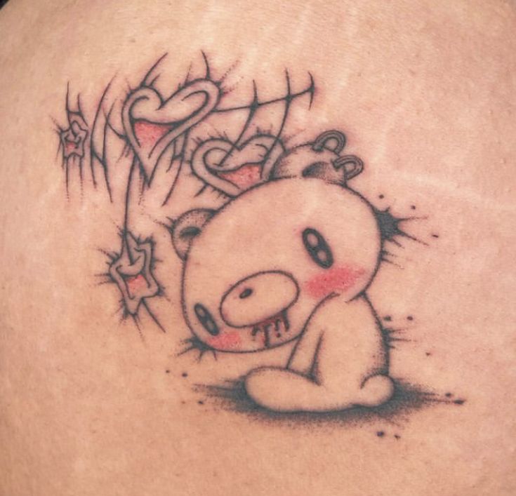 a tattoo on the back of a woman's shoulder with an image of a teddy bear