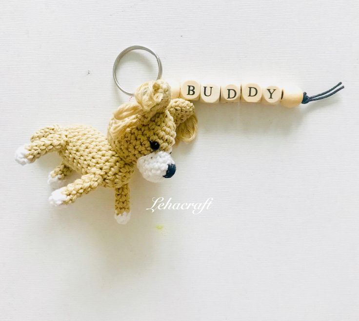 a crocheted keychain with a stuffed animal hanging from it's side