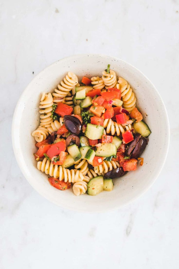 a white bowl filled with pasta and vegetables