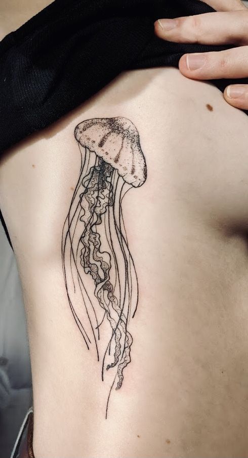 a woman's stomach with a tattoo of a jellyfish