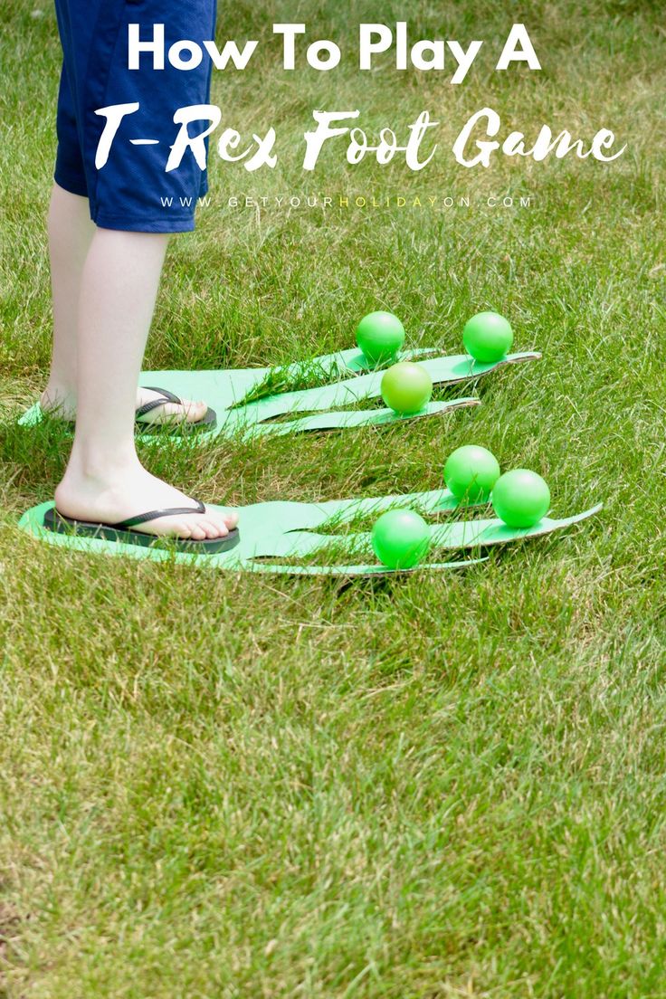 a person standing on top of a green frisbee golf set in the grass