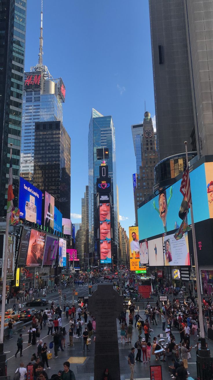 people are walking around in the city with tall buildings and billboards on both sides