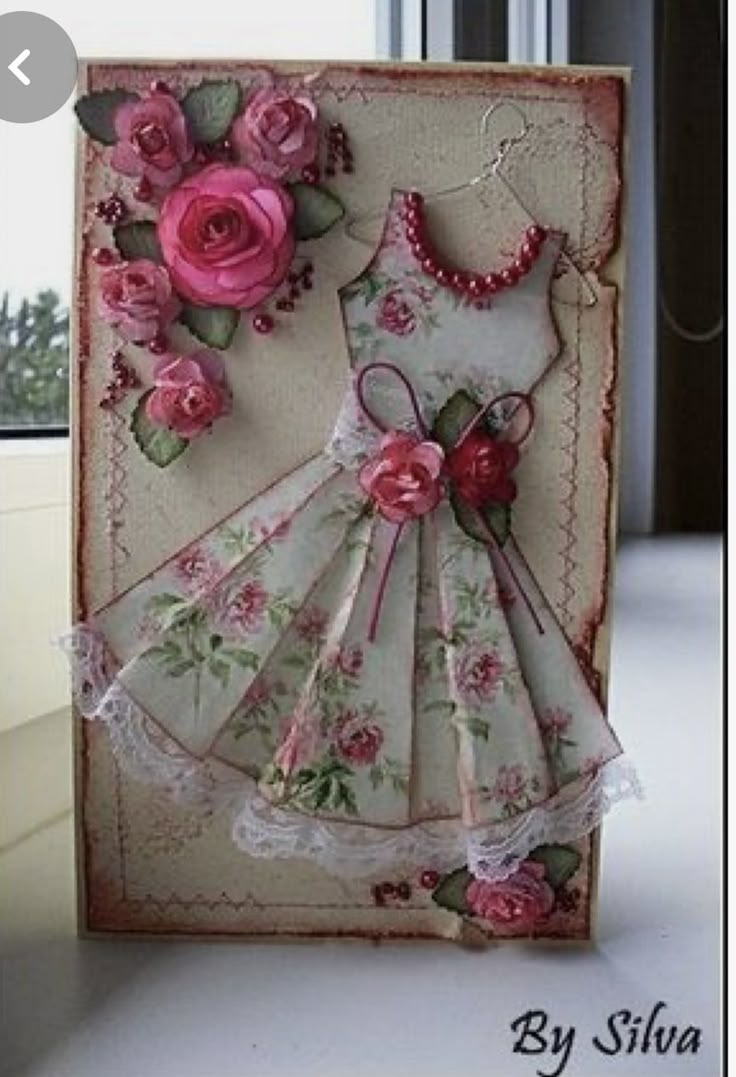 a handmade card with pink roses and lace on the edges, featuring a dress