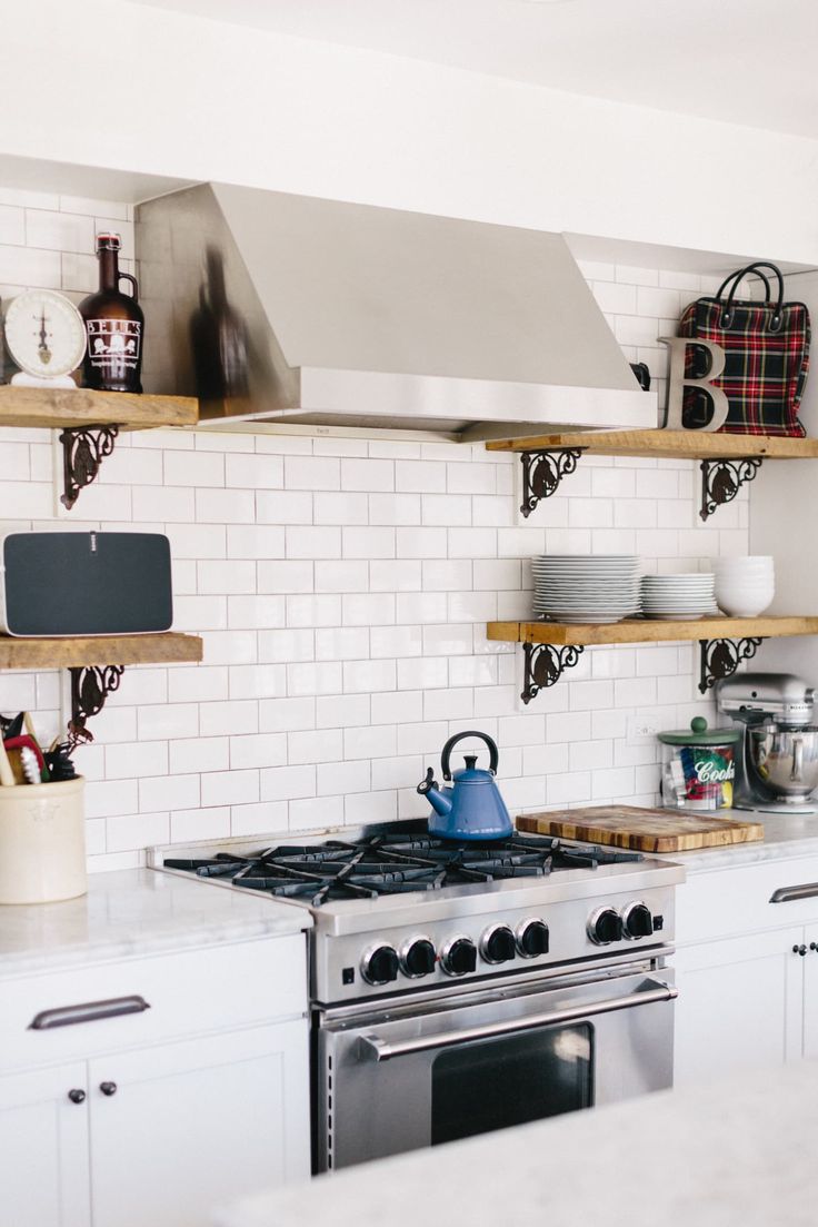 a stove top oven sitting inside of a kitchen next to white counter tops and cabinets