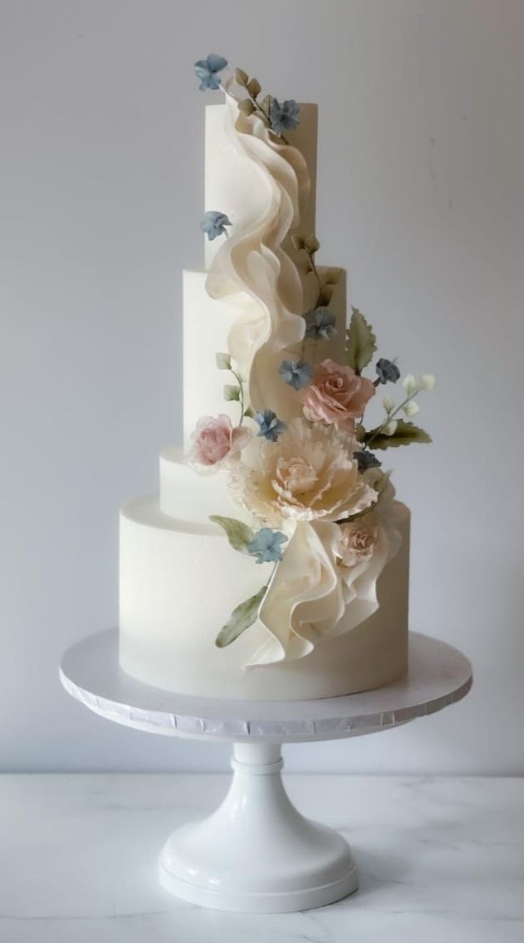 a three tiered white cake with flowers on it