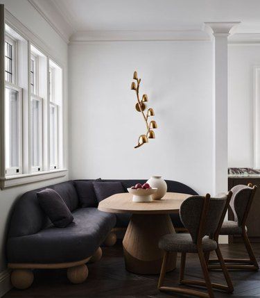 a corner table with two chairs and a bowl of fruit on it