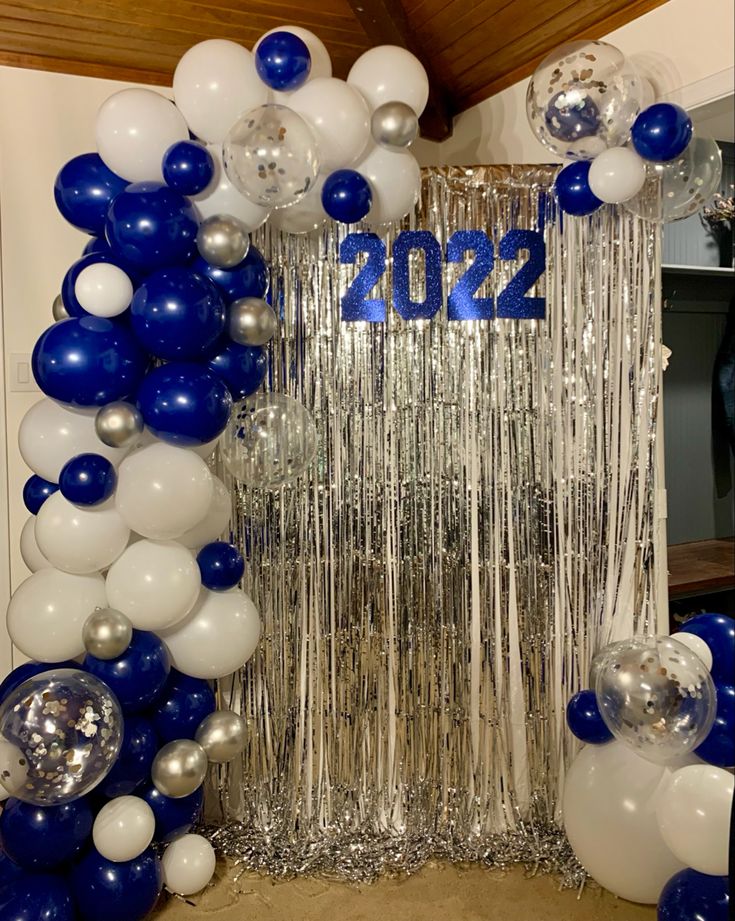 balloons and streamers decorate the entrance to a new year's eve party in blue and white