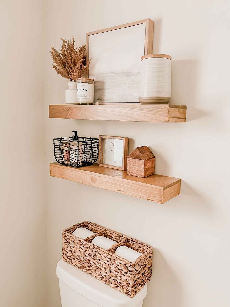 two wooden shelves above a toilet in a bathroom with white walls and wood flooring