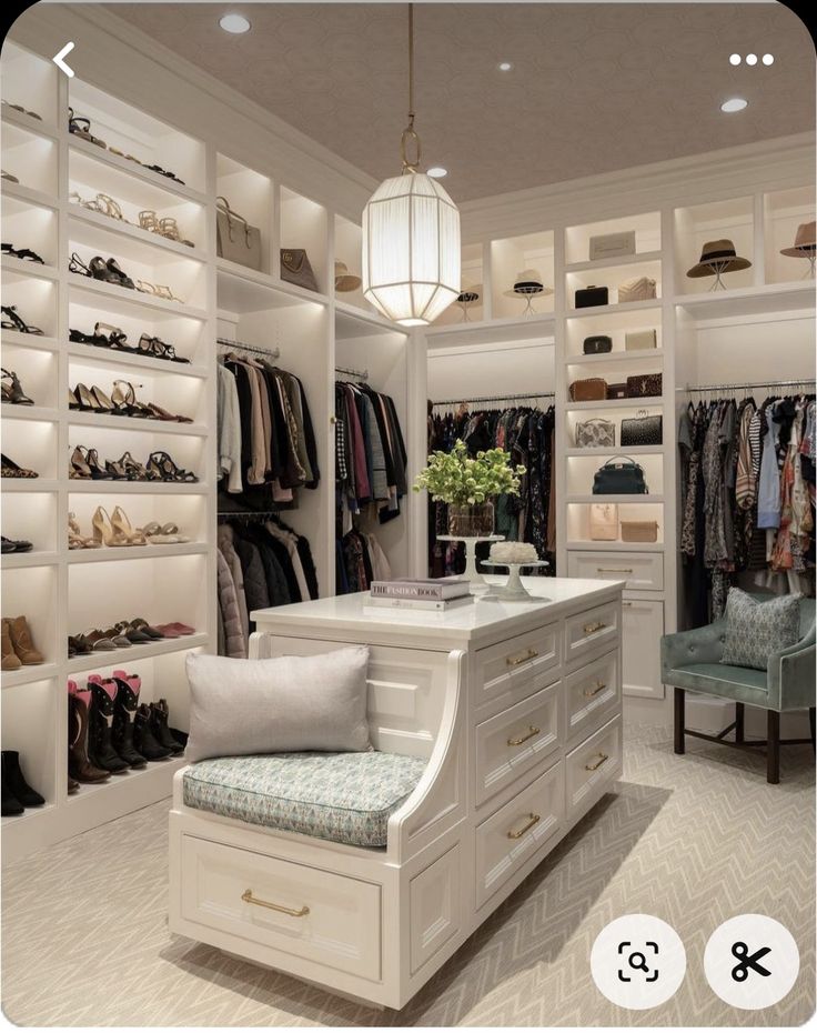 a walk in closet filled with lots of clothes and shoes on shelves next to a bench