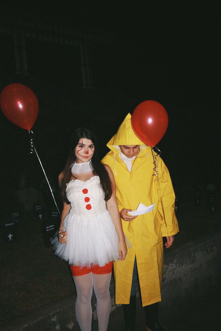 two people in costumes standing next to each other with red balloons attached to their heads