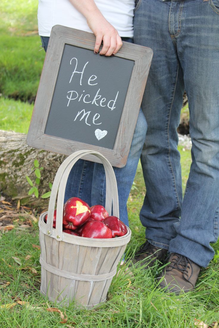 a man and woman standing next to each other holding a sign that says he picked me