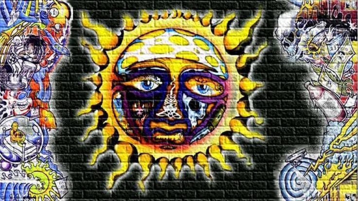 an artistic painting on the side of a brick wall with sun and moon faces in different colors