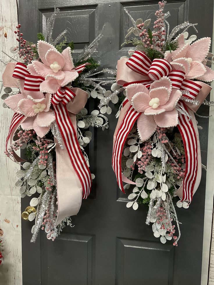 two wreaths with flowers and ribbons on the front door