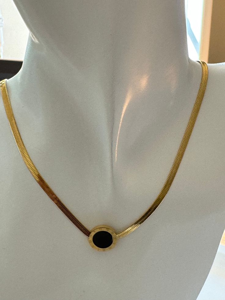 The Luminous Onyx Elegance necklace exudes sophistication. Its delicate gold chain cradles a circular pendant, mysterious and dark as midnight. Within its obsidian heart lies the allure of hidden constellations. Wear it as a celestial whisper against your skin, a reminder that even in darkness, there is beauty. Gold Plated Round Costume Jewelry Necklace, Gold Plated Costume Jewelry Necklace, Round Gold Plated Costume Jewelry Necklace, Black Metal Snake Chain Jewelry, Formal Black Enamel Round Pendant Necklace, Black Round Jewelry With Adjustable Chain, Black Jewelry With Adjustable Round Chain, Elegant Black Stainless Steel Chain Necklace, Gold Onyx Pendant Jewelry