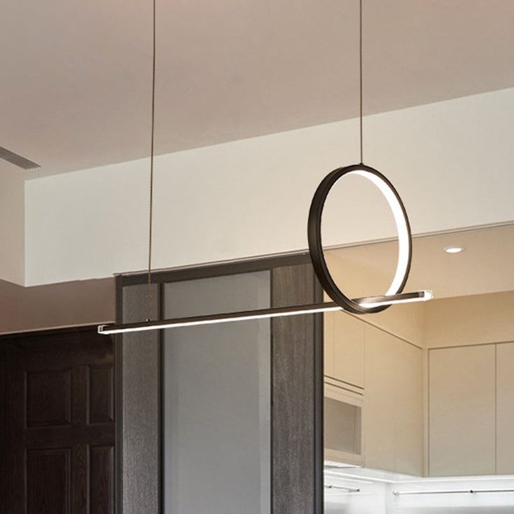 a modern kitchen with an oval light hanging from the ceiling