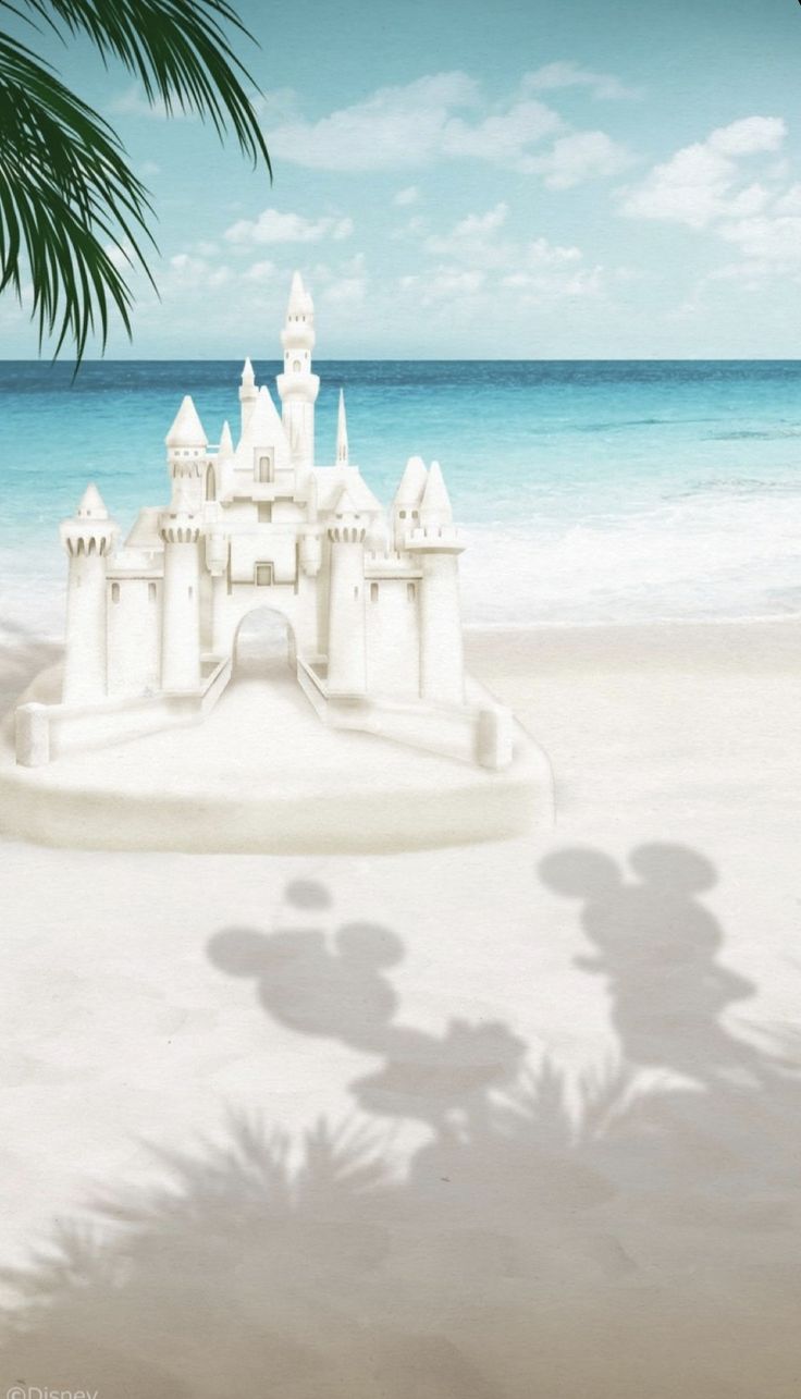 a sand castle on the beach with palm trees