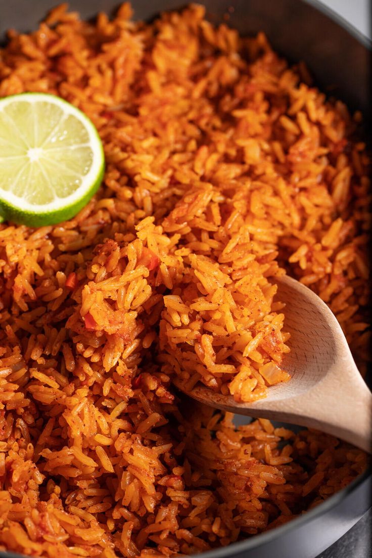 a pan filled with rice and a lime wedge