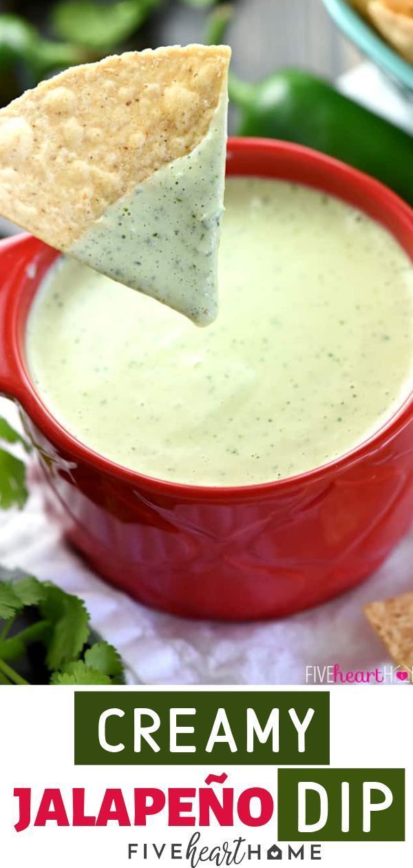 a red bowl filled with creamy jalapeno dip next to tortilla chips