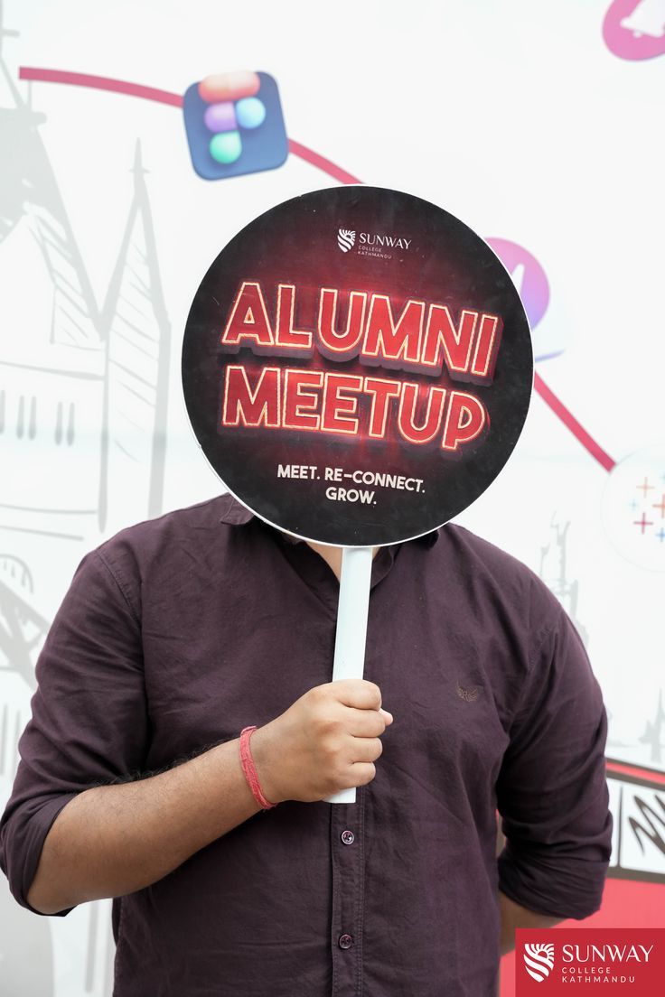 a man holding up a sign with the word'alumin meetup'on it