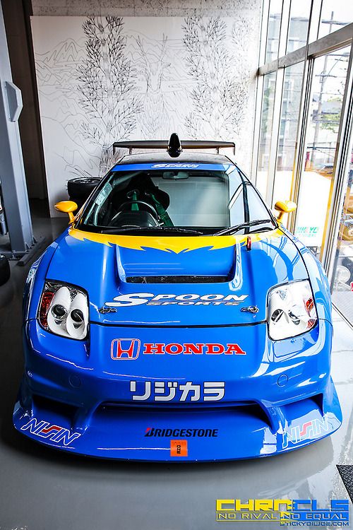 a blue and yellow sports car parked in a garage