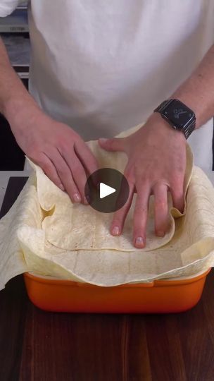 a person in an apron is kneading some food