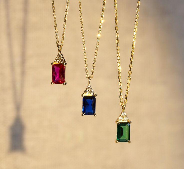 Our emerald cut necklace is 14k solid gold and it is available in three different gemstone options; blue, green, and pink. All the colors have a dainty and charming style that everyone loves it!  When considered as a gift, our gold dainty gemstone pendant necklace will be a perfect gift that makes your loved ones happy on their birthday, mother's day, valentine's day, anniversaries, graduation, or women's day.  🎁 If you want, you can add a gift note for your loved ones. It arrives in a special Cubic Zirconia Emerald Necklace For Gifting, Cubic Zirconia Emerald Necklace Gift, Gift Cubic Zirconia Emerald Necklace, Rectangular Gemstone Accented Necklaces As Gift, Gift Gemstone Necklace With Baguette Cut, Gold Emerald Necklace With Baguette Cut For Gift, Rectangular Gemstone Accents Necklace As Gift, Rectangular Gemstone Accents Necklace For Gift, Rectangular Gemstone Accent Necklaces For Gifts