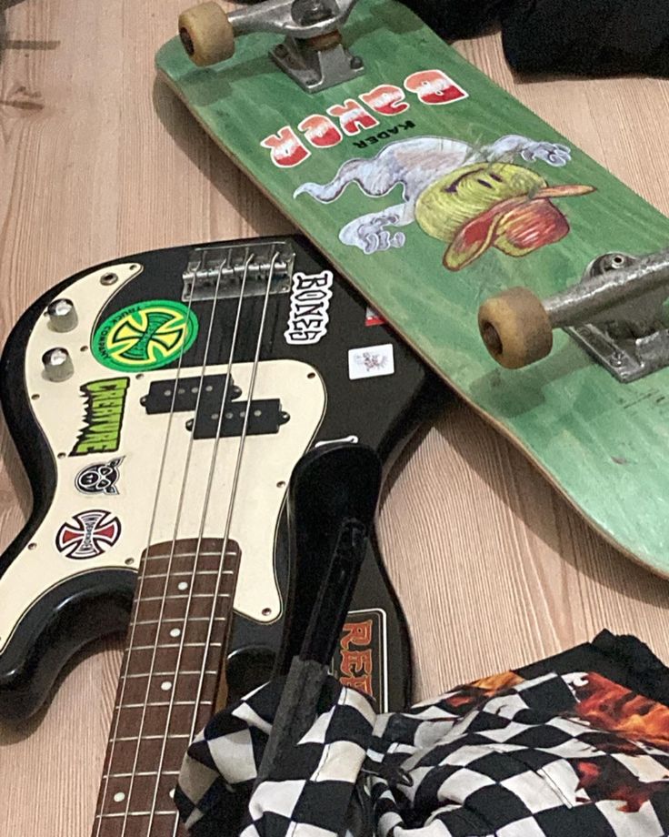 two skateboards, one with an electric guitar and the other with stickers on them