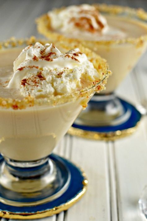 two desserts with whipped cream and cinnamon sprinkles in small glass dishes