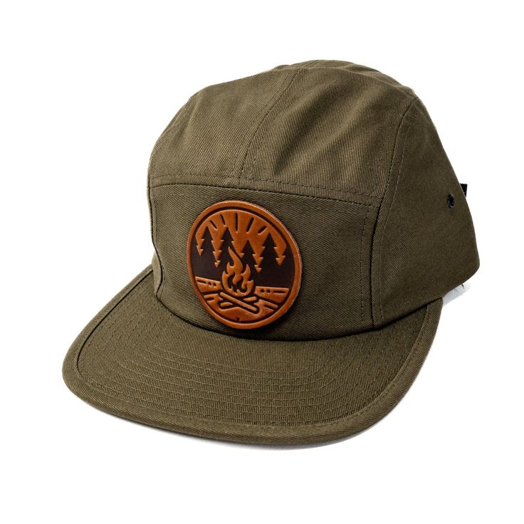 Get Fired Up for Adventure with this Campfire Cap! The patch on this hat features a classic campfire scene, capturing the timeless allure of the great outdoors. It's a simple yet evocative image: two logs ablaze with flames reaching upwards, cradled by a circle that hints at the unity and completeness of nature. The trees standing sentinel on either side anchor the scene in the wild, calling to mind the serenity of the woods and the simple pleasures of a fireside chat under the stars. Each cap i Campfire Scene, Jockey Hat, Field Notes Cover, Moleskine Cover, Classic Campers, Leather Mouse, Leather Mouse Pad, Oxblood Leather, Dog Collars & Leashes