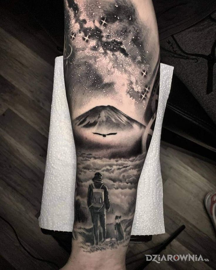 a man's arm with a tattoo on it and an image of a mountain in the background