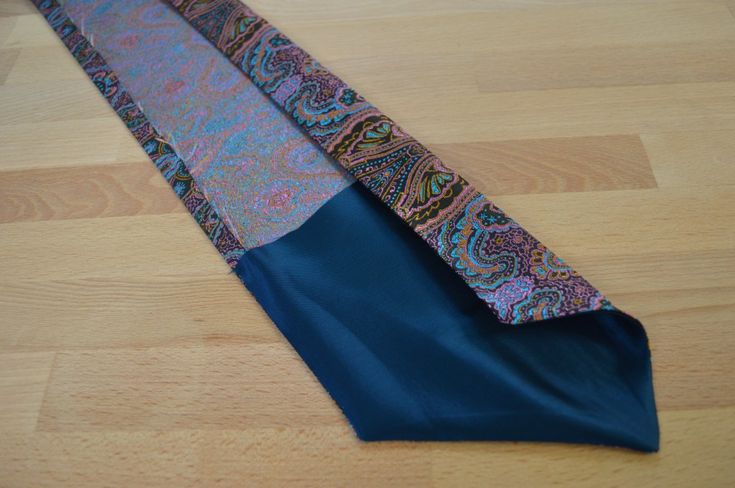 a blue tie laying on top of a wooden floor