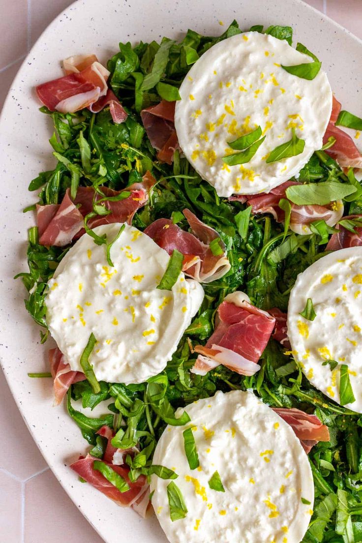 a white plate topped with salad covered in cheese