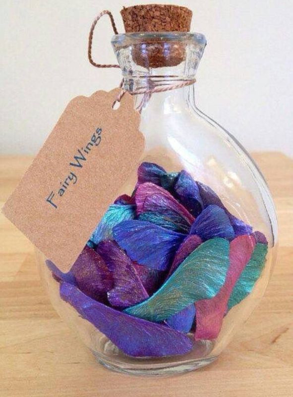 a glass bottle filled with lots of colorful yarn