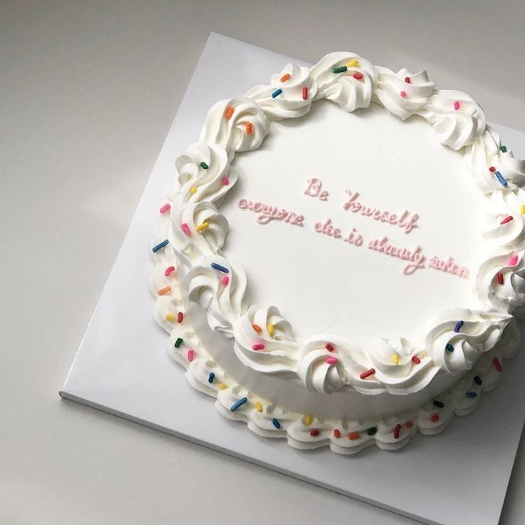 a birthday cake with white frosting and colorful sprinkles