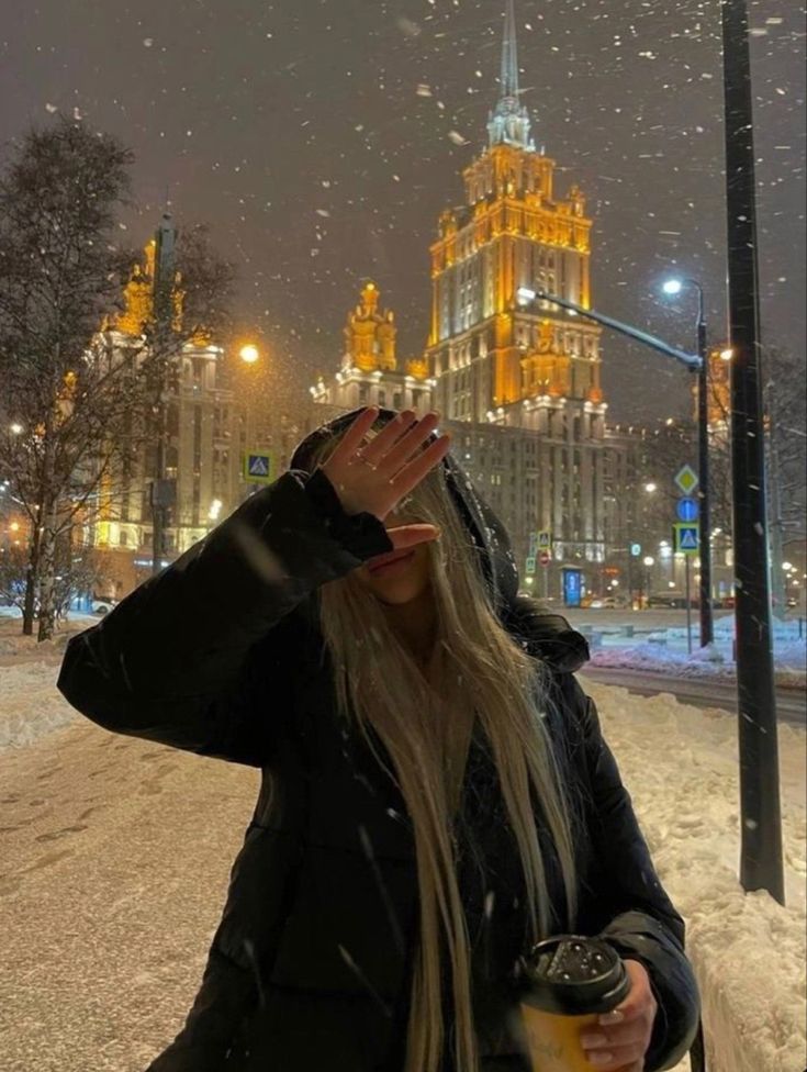 a woman standing in the snow covering her eyes