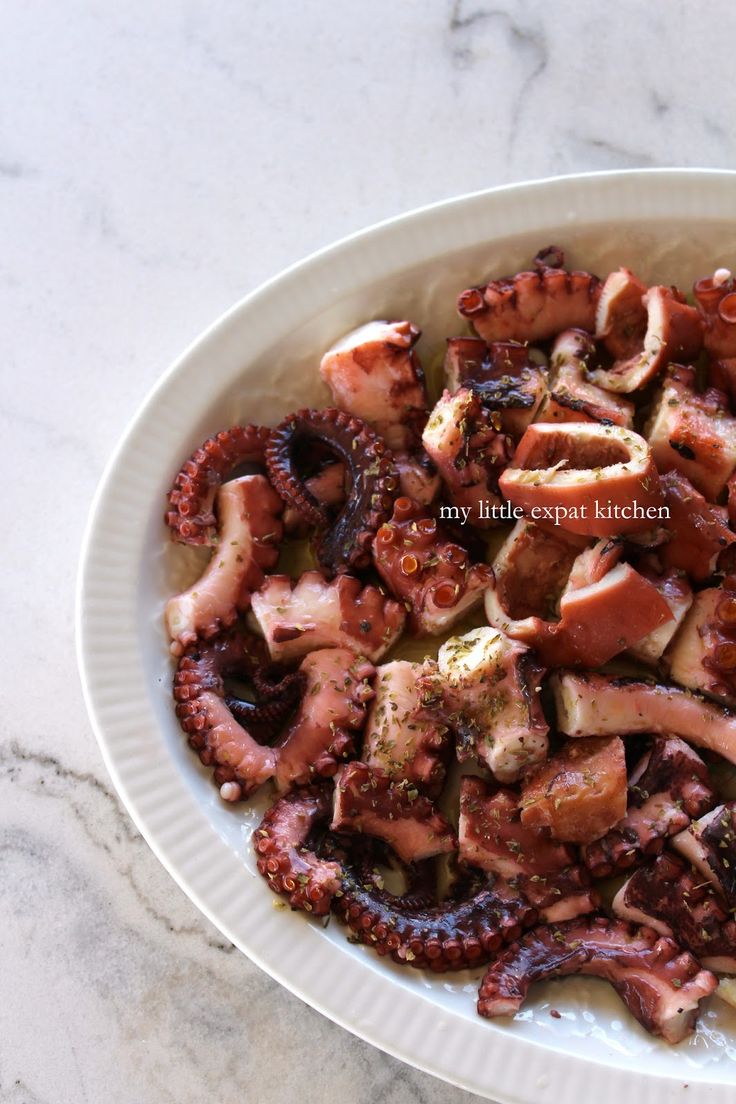 an octopus dish is served in a white bowl