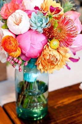 a vase filled with lots of flowers on top of a wooden table next to an instagram page