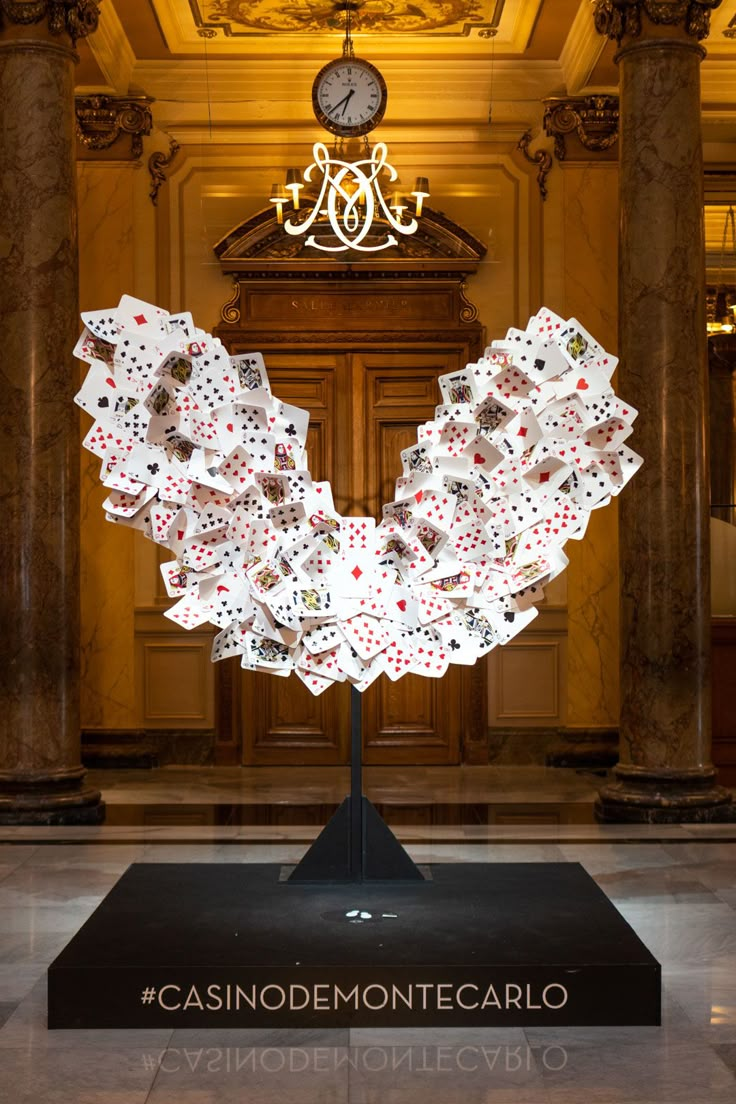 a casino themed sculpture in the lobby of a building with columns and chandelier