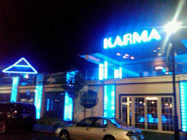 a car parked in front of a building with lights on it's sides at night