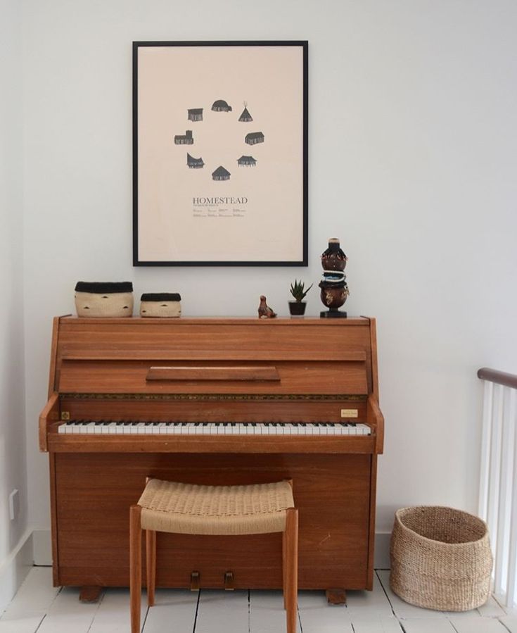 a piano sitting in the corner of a room next to a chair and rug on the floor