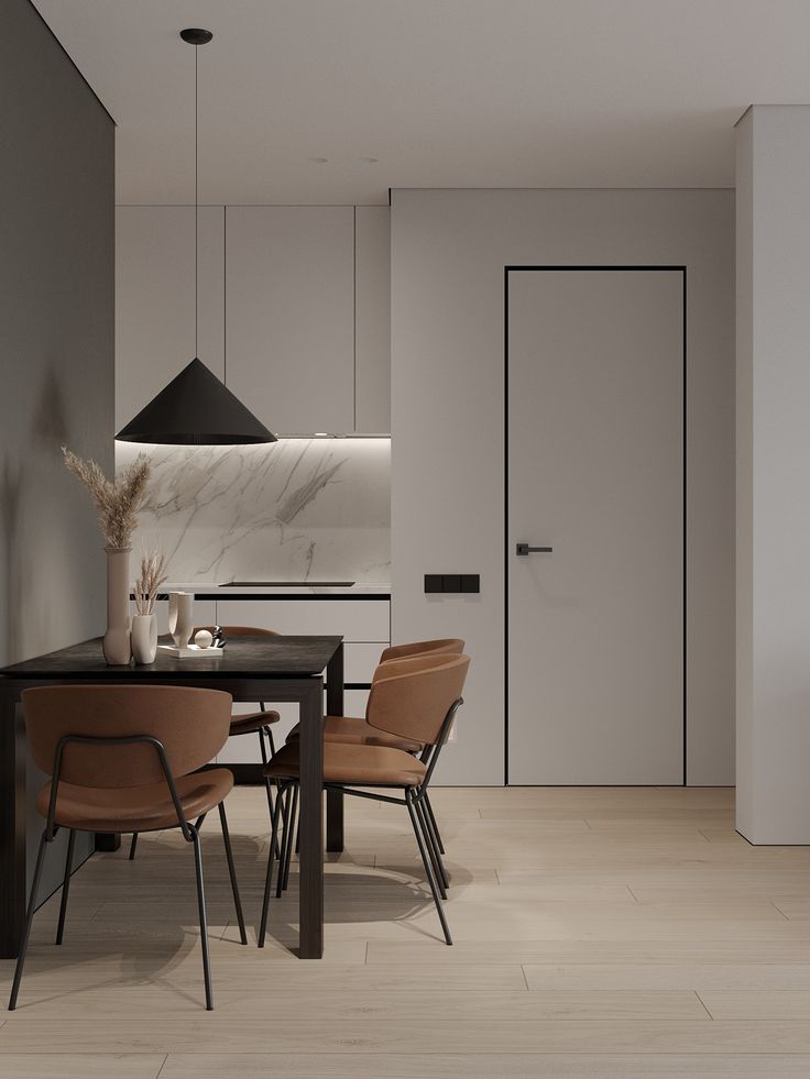 a dining room table and chairs in front of a white wall with a black door