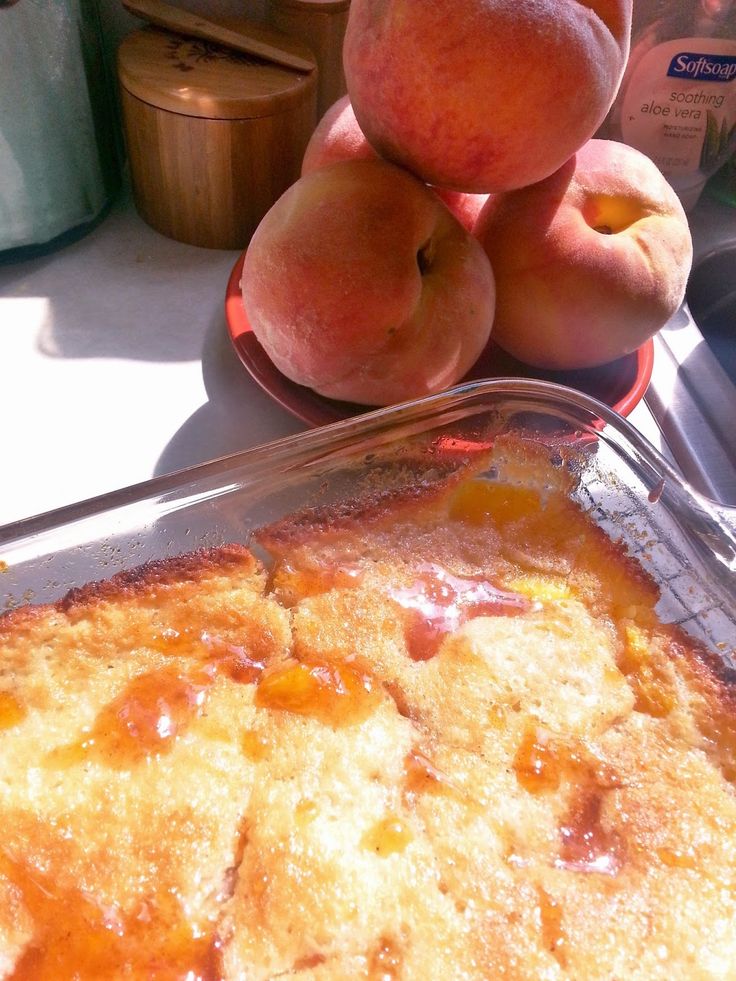 peach cobbler with fresh peaches in the background on a sunny day, ready to be eaten