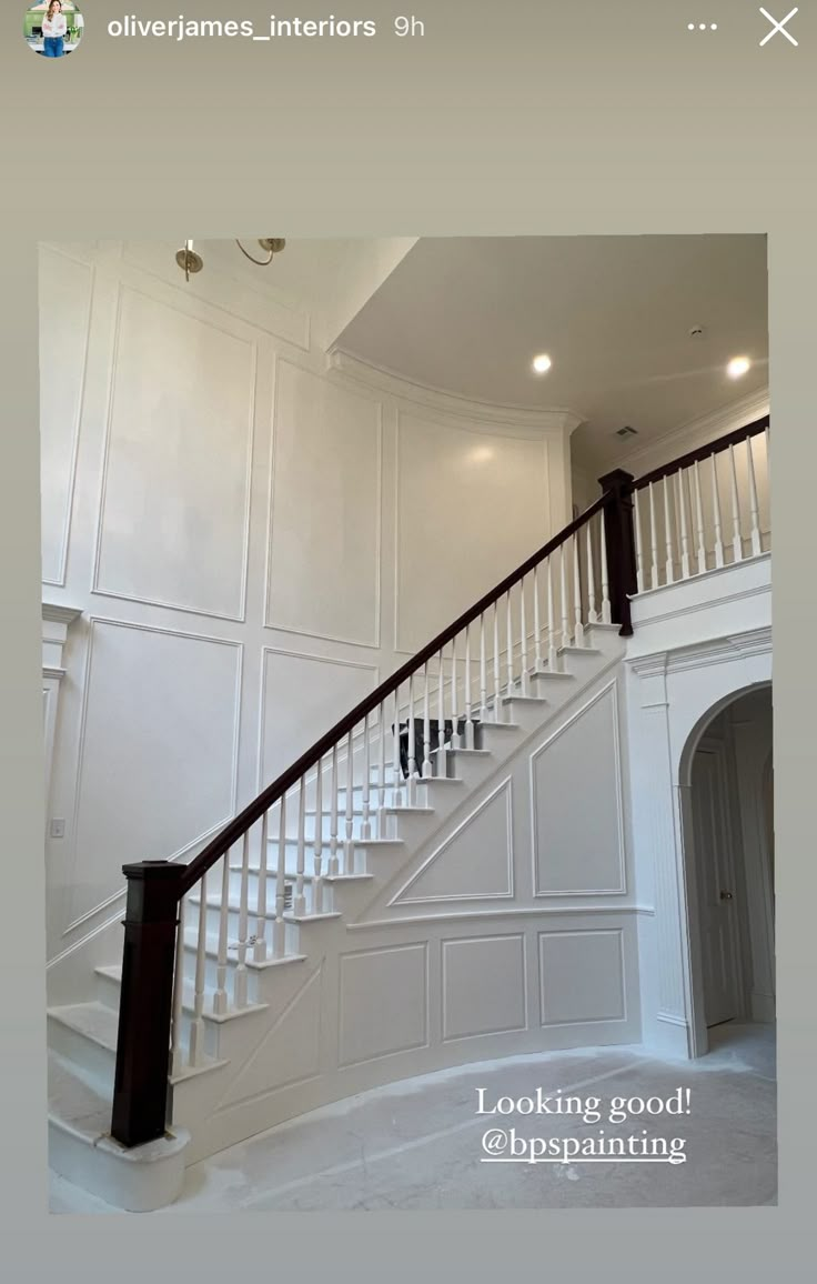 an empty room with white walls and stairs