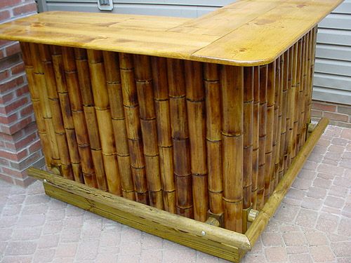 a bamboo bar sitting on top of a brick floor next to a building with a door