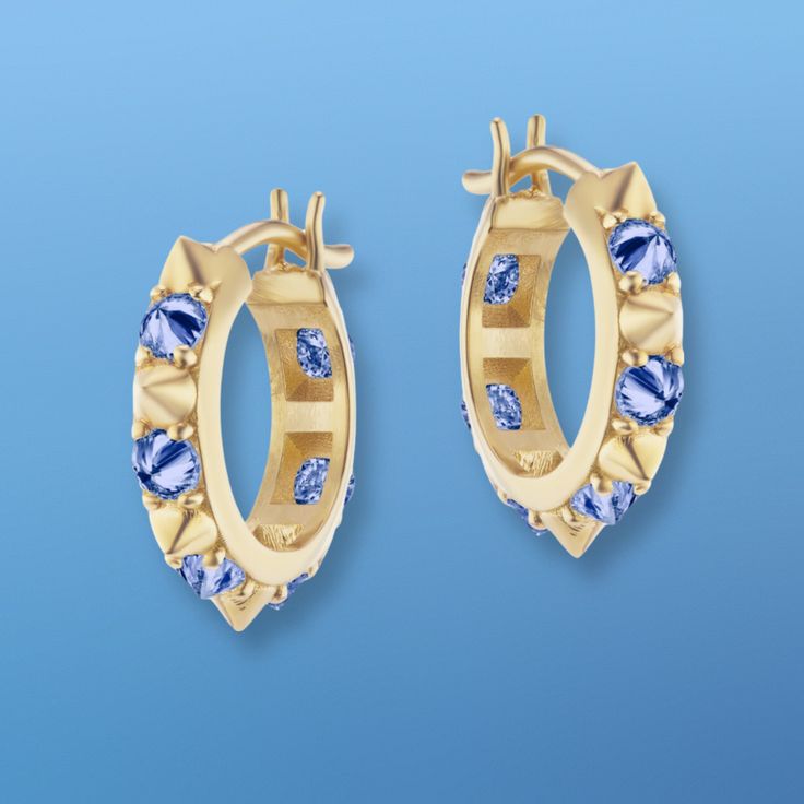 AK's 'Valerie' blue sapphire and gold mini hoop earrings from her 'Attitude' Collection were inspired by movement. The inverted blue sapphires and gold spikes create an edginess to this classic hoop earring style. This vibe has been reinvented for the modern woman whose aesthetics are a fusion of confidence, femininity, and classic form. The inverted blue sapphires and gold spikes along the hoop create a beautiful profile from the side and are visible when you wear your hair up or tucked behind Luxury Blue Hoop Jewelry, Luxury Blue Hoop Earrings, 1970s Punk, Beautiful Profile, Hoop Earrings Style, Mini Hoop Earrings, Classic Elegance, Up Hairstyles, Modern Woman