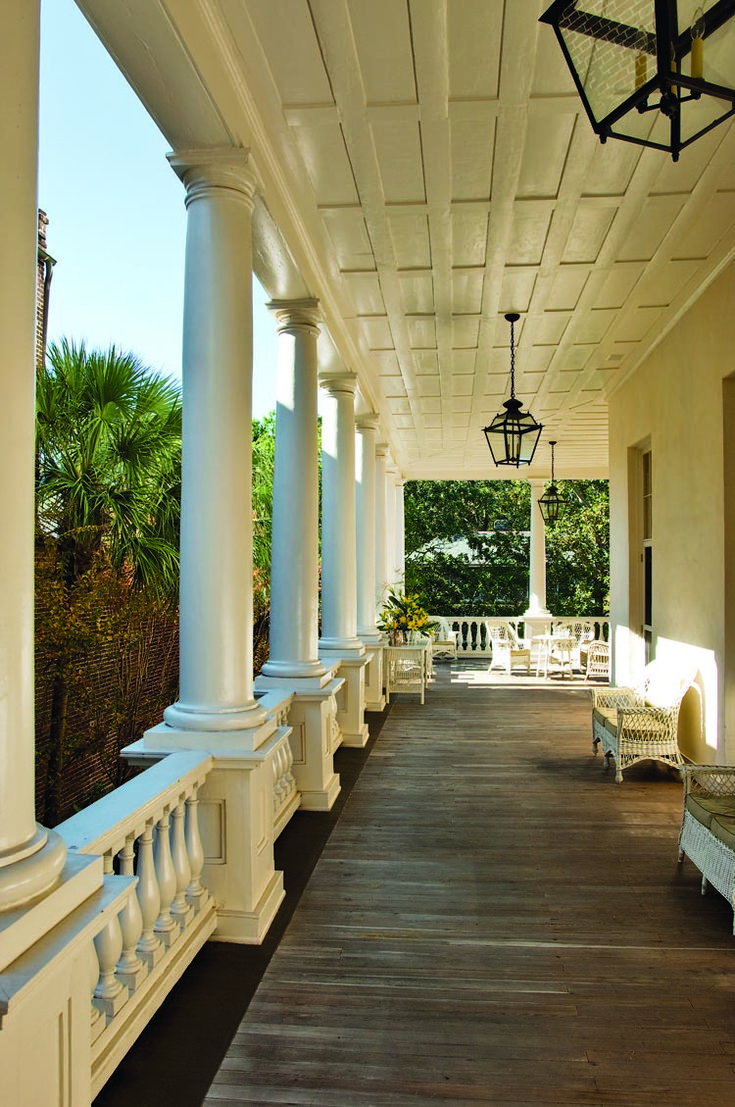 the porch is lined with white chairs and columns