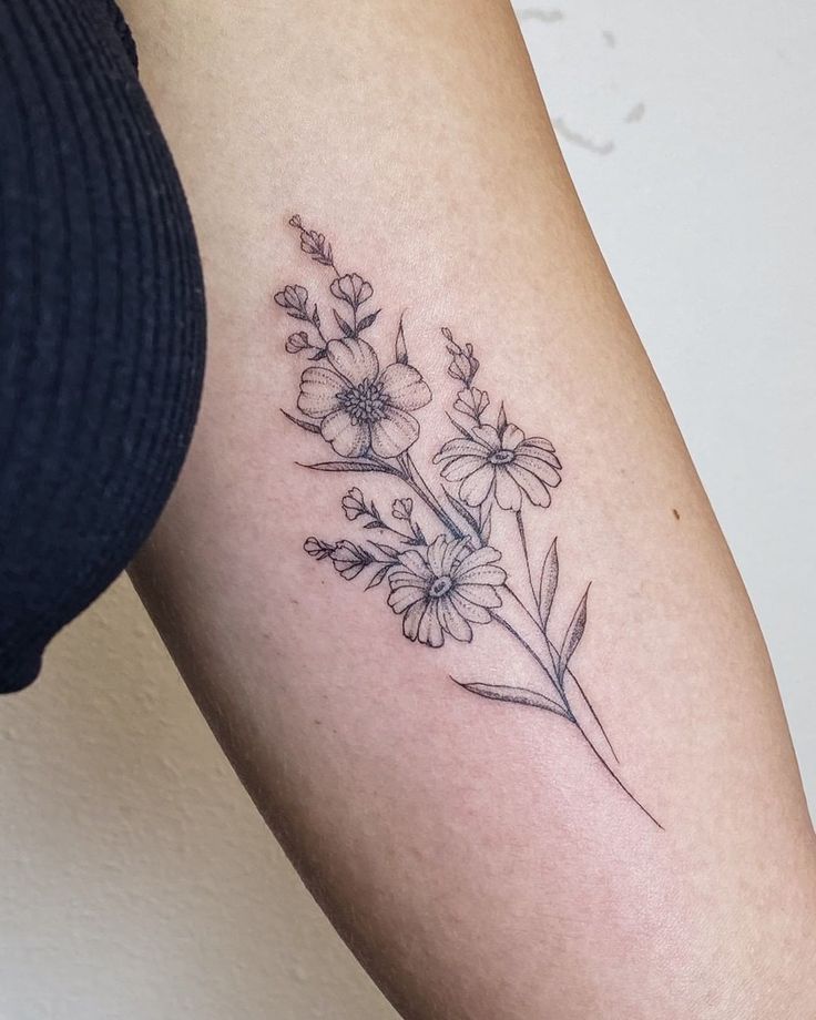 a woman's arm with a flower tattoo on the back of her left arm