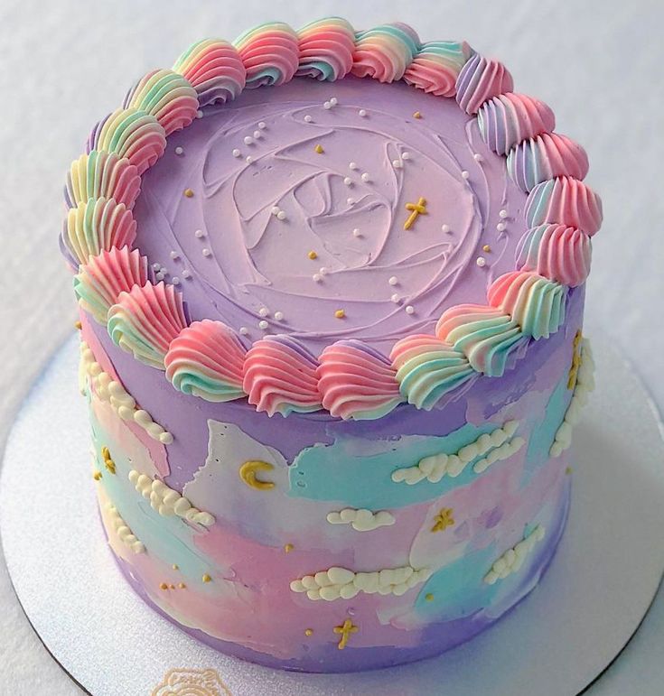 there is a cake that has been decorated with pastel colors and stars on it