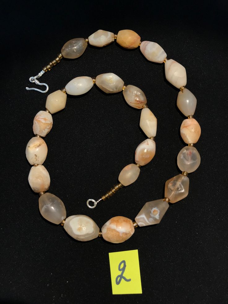 A beautiful string of Bended white agate natural found from Afghanistan dating 1800 yrs. They are found at that time in Afghanistan mostly but also some found in India and Pakistan too. They were used as a special charm jewellery by the affluents at that time period. Beautiful counter bronze are decorated further in between the beads. Rondelle Agate Jewelry With Natural Stones, Antique Gemstone Beaded Jewelry, Agate Rondelle Natural Stone Jewelry, Antique Round Gemstone Beads Jewelry, Antique Carnelian Jewelry With Natural Stones, Vintage Jewelry With Oval Gemstone Beads, Spiritual Tumbled Gemstone Beads Jewelry, Antique Beaded Jewelry With Oval Beads, Antique Agate Amber Jewelry